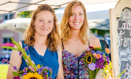 Two women holding flowers in a park